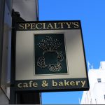 Sidewalk view attached business sign